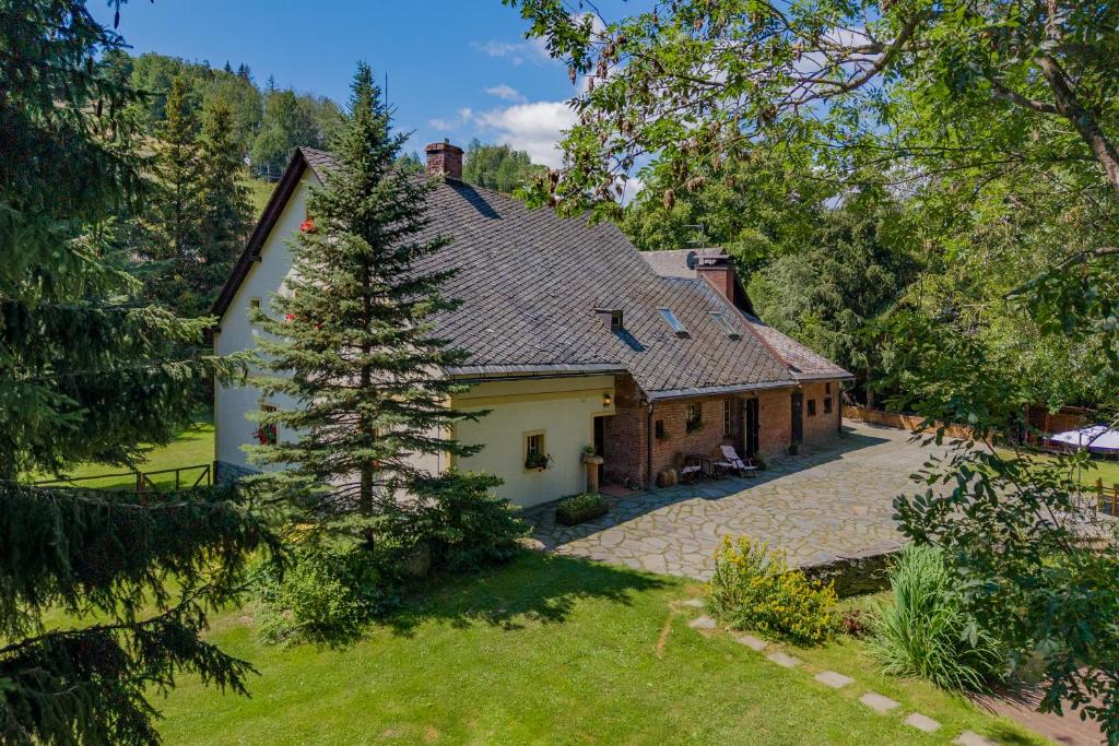 a large white house with a roof at Apartmány Stodola in Malá Morávka