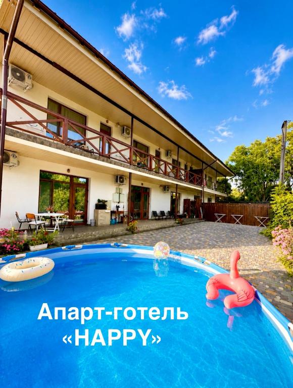 a swimming pool in front of a house at Апарт-готель HAPPY in Fontanka