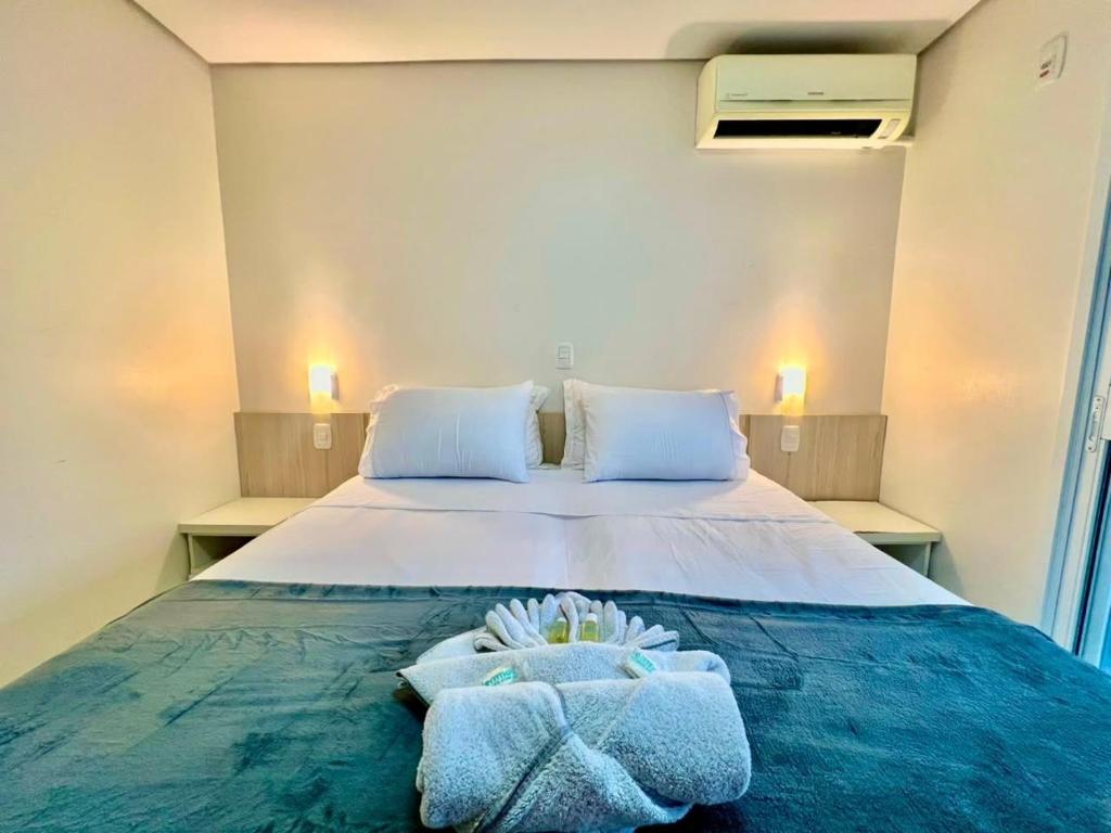 a bedroom with a bed with towels on it at Executive - 106 No Garage in Caxias do Sul