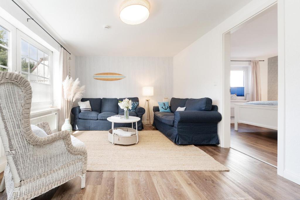 a living room with two blue couches and a table at Huus 41 in Wulfen auf Fehmarn