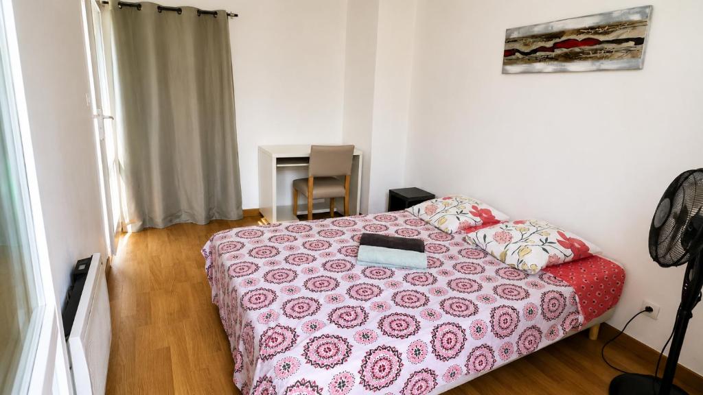 a bedroom with a bed with a pink bedspread at Grand T2 calme avec parking privé à Toulouse in Toulouse