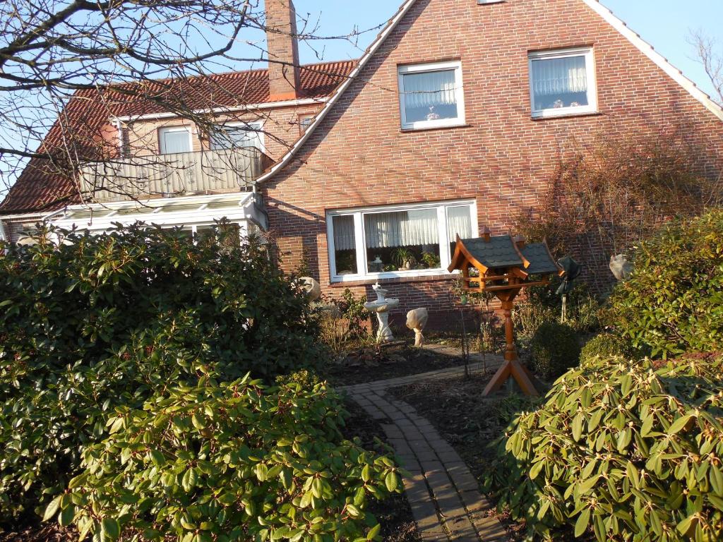 a brick house with a garden in front of it at Gästehaus an der Wieke in Berumerfehn