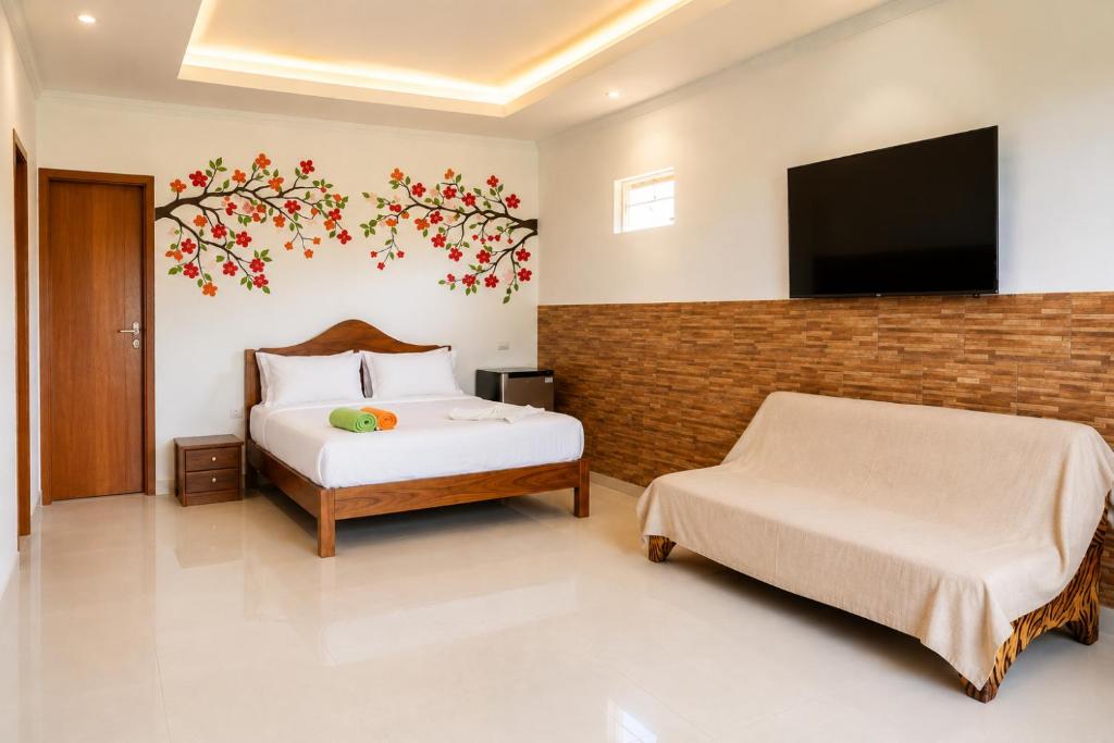 a bedroom with two beds and a flat screen tv at Mandinga Guest house in São Tomé