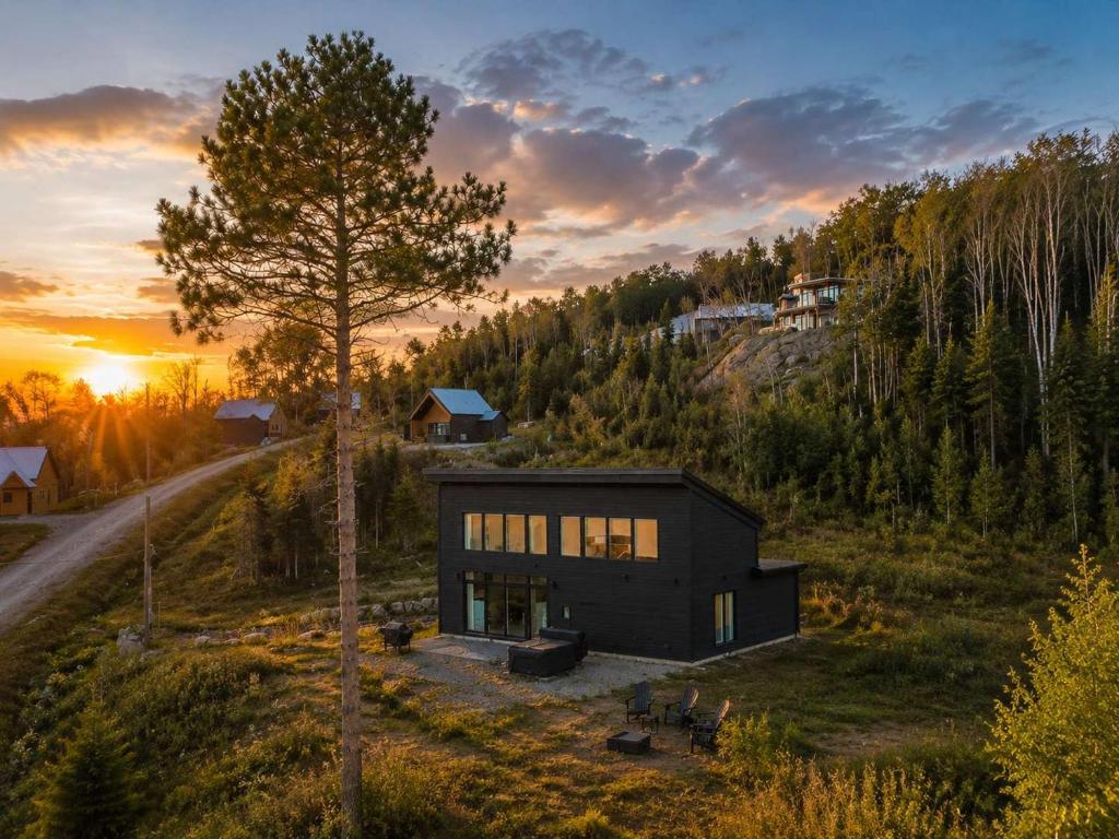 a house on a hill with a tree at Modern Comfort - Spa - Mountain - Chalet KNOX in Saint Come
