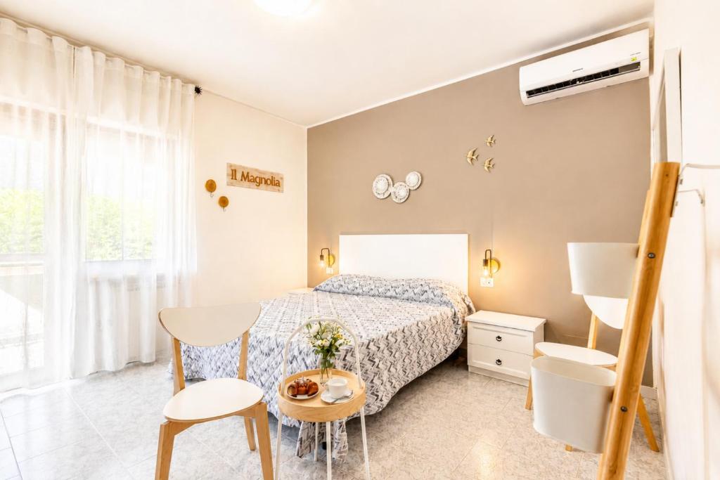 a bedroom with a bed and a table and chairs at Il Magnolia in Francavilla al Mare