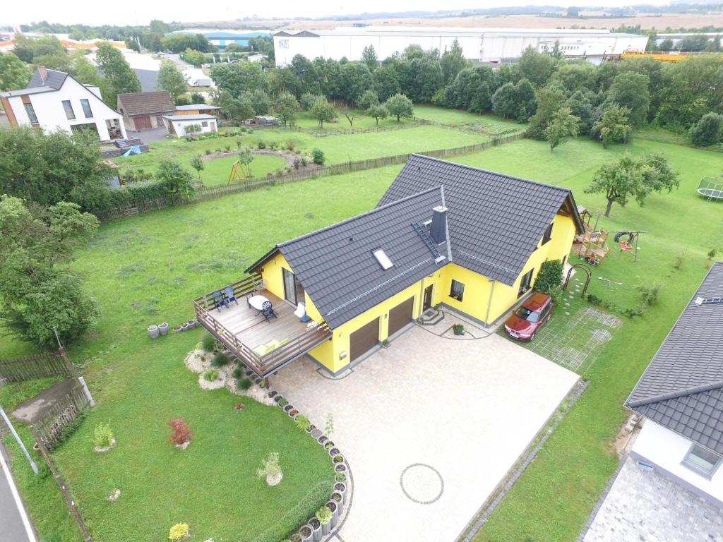 una vista aérea de una casa amarilla con patio en Ferienwohnung Unterwellenborn, en Unterwellenborn