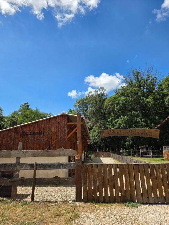 a wooden fence in front of a barn at Le ranch de Chant'alouette in Étauliers