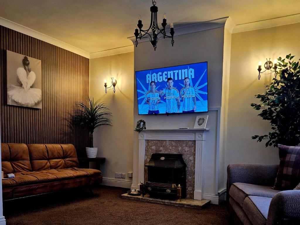 a living room with a tv above a fireplace at Miners Lamp Apartment in Easington