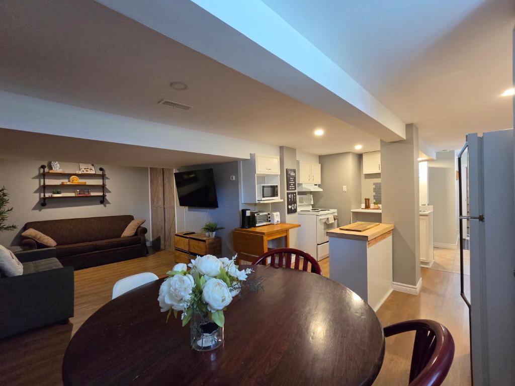 a living room with a wooden table and a kitchen at Guest house in Shawinigan