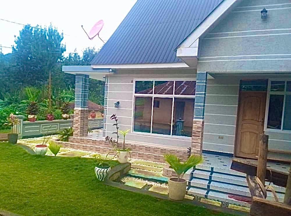 a small house with a porch and a yard at Usambara Homes in Manga