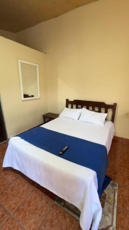 a bedroom with a large bed with a blue blanket at Accommodation #7 in Copán Ruinas