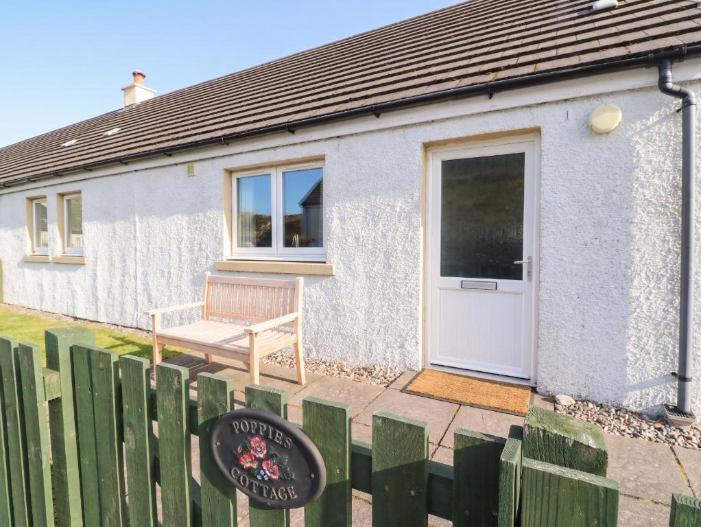 a small house with a bench in front of it at Poppies Cottage in Craignure