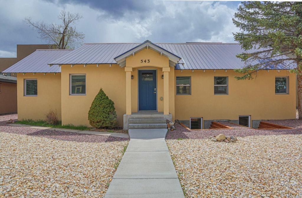 a yellow house with a blue door at Sleeps 10 Walkable to Everything Pets Game Room in Salida