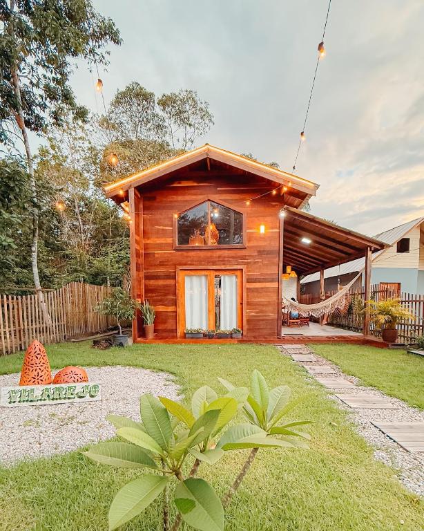 a log home with a yard with a house at Vilarejo in Belém