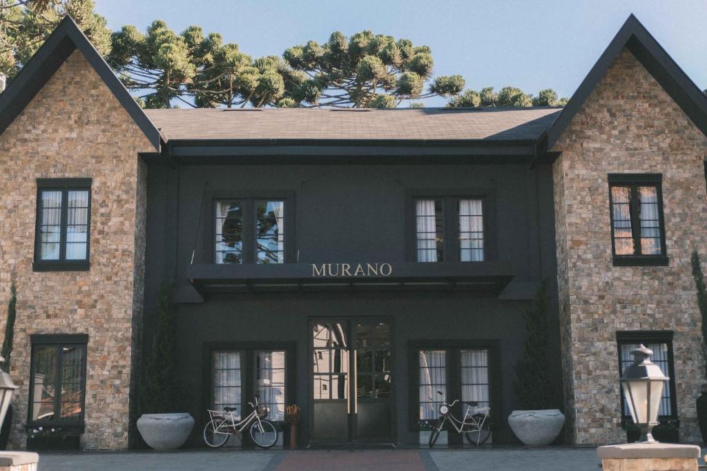 a black building with bikes parked outside of it at Pousada Murano in Campos do Jordão