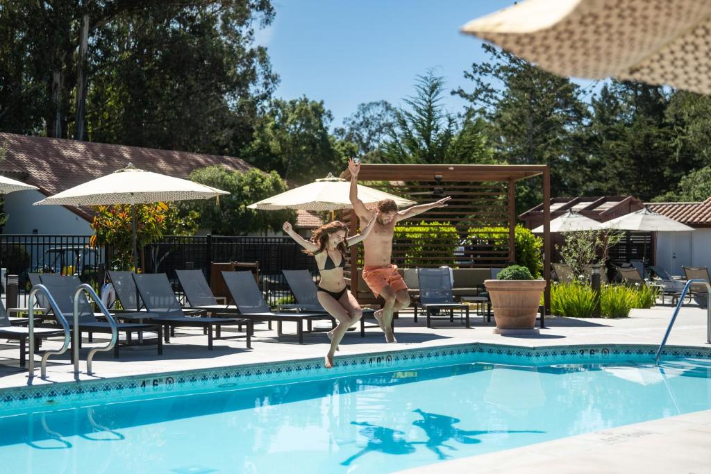 a couple of people jumping into a swimming pool at Chaminade Resort & Spa in Santa Cruz