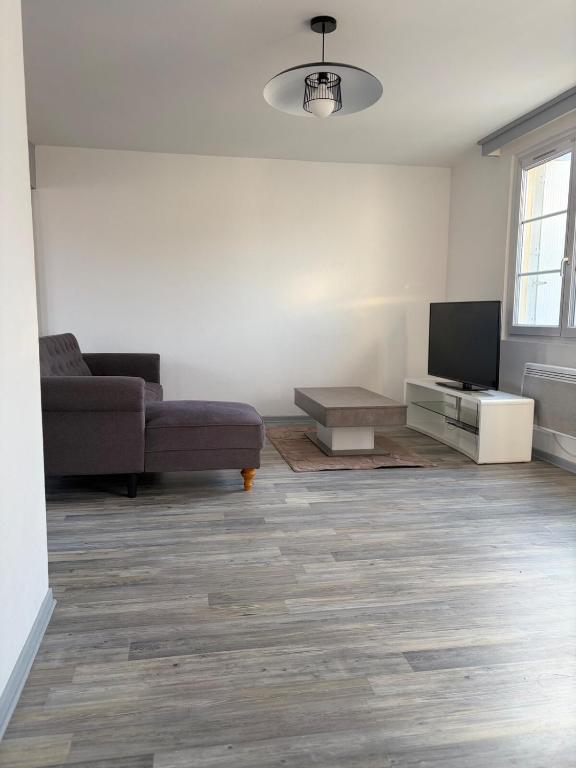 a living room with a couch and a flat screen tv at Le clos du landreau in Saint-Père-en-Retz