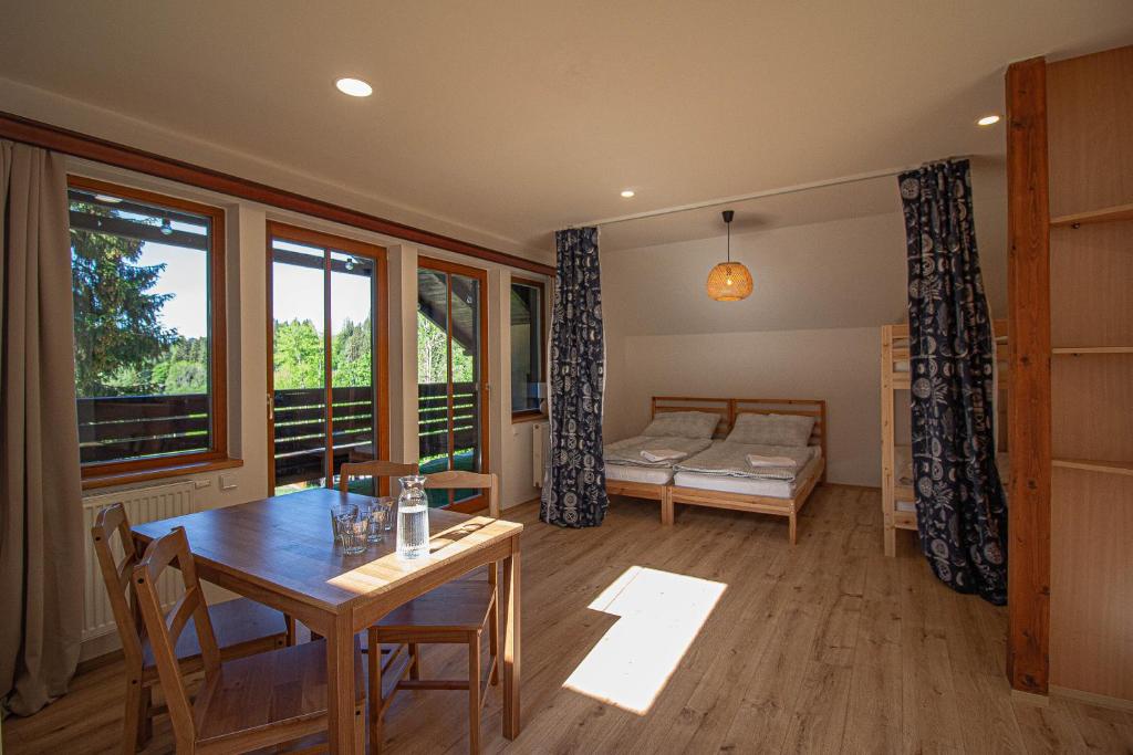 a living room with a table and a bed at Apartmány Kořenný in Korěnný