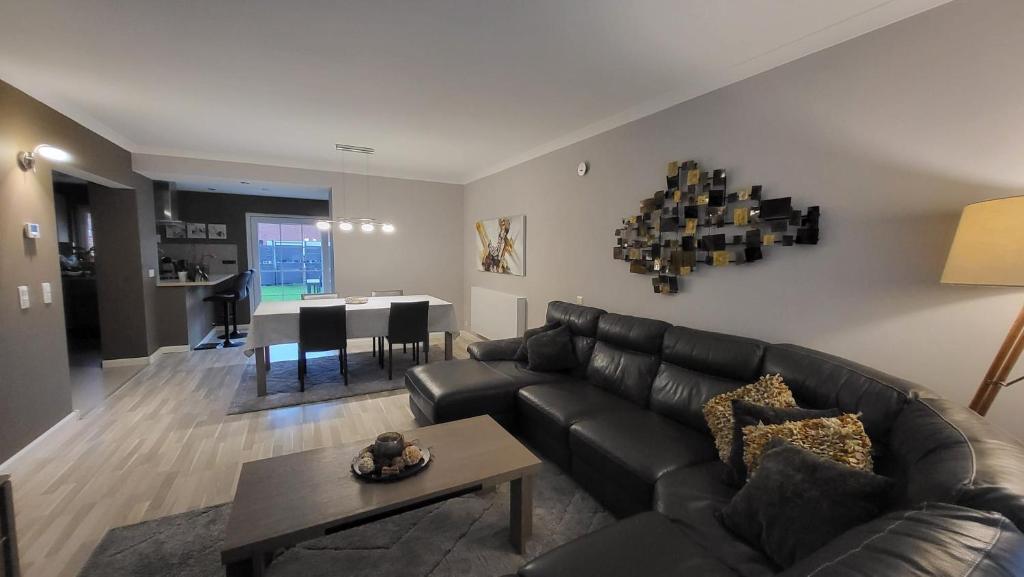 a living room with a leather couch and a table at Tomorowland Woning in Boom in Boom