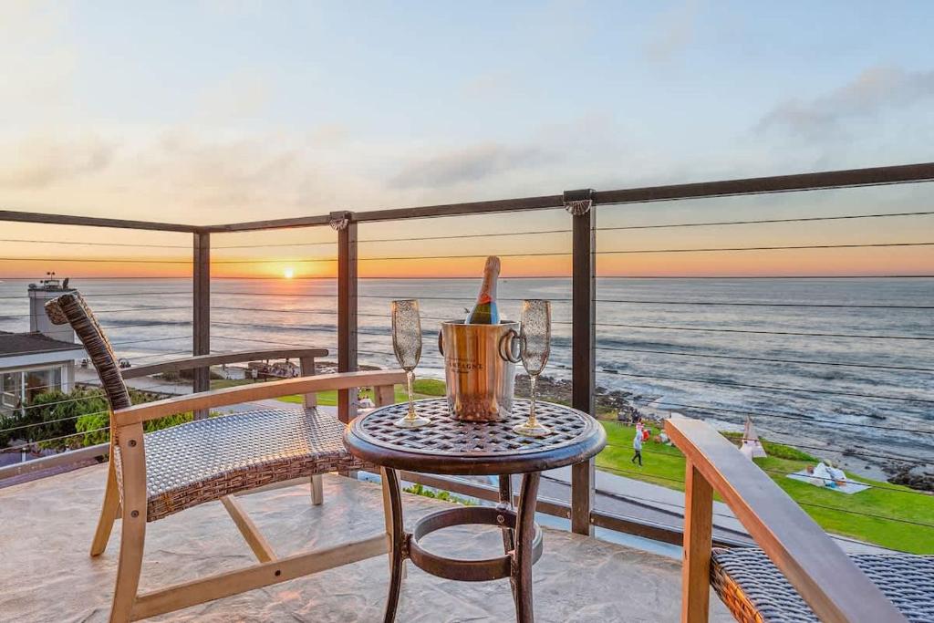 a table and chairs on a balcony with a view of the ocean at Sur La Mer, beachfront, tidal pools in San Diego