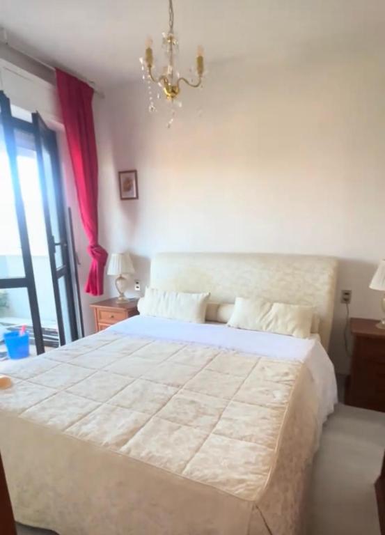 a bedroom with a large white bed with a chandelier at Maison Sofia Mare in Silvi Marina
