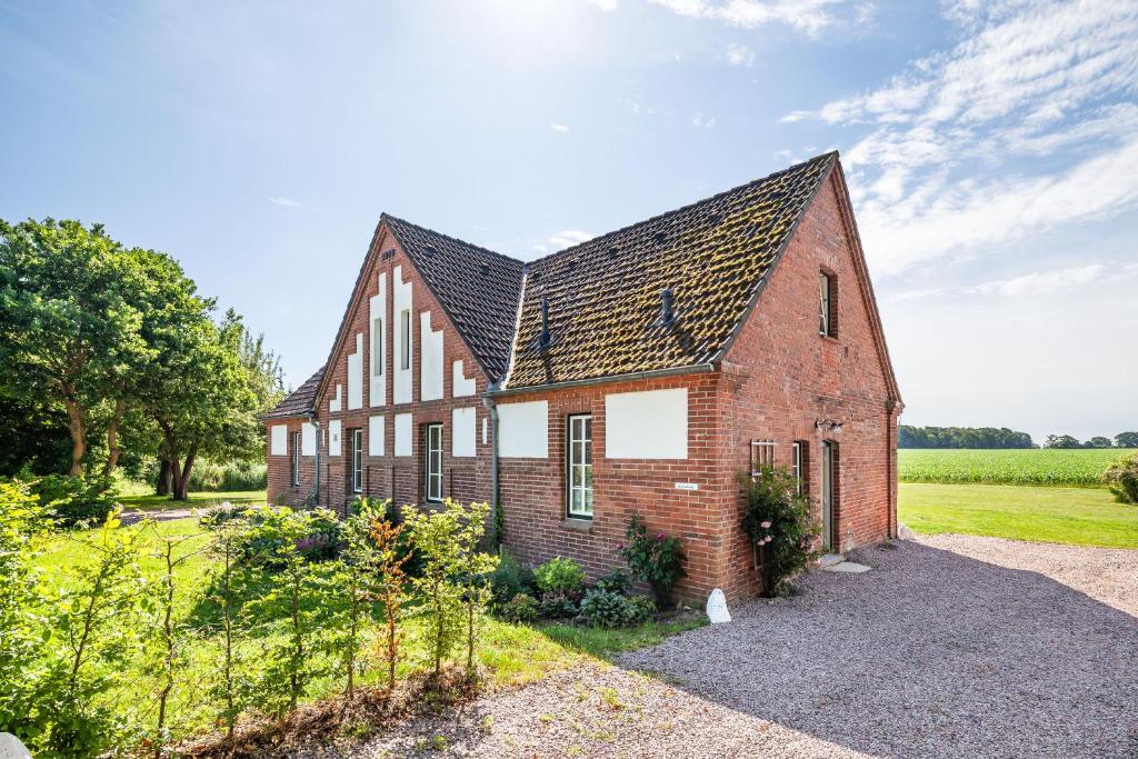 a brick house with a black roof at Kreuzkate-Ostholstein in Manhagen