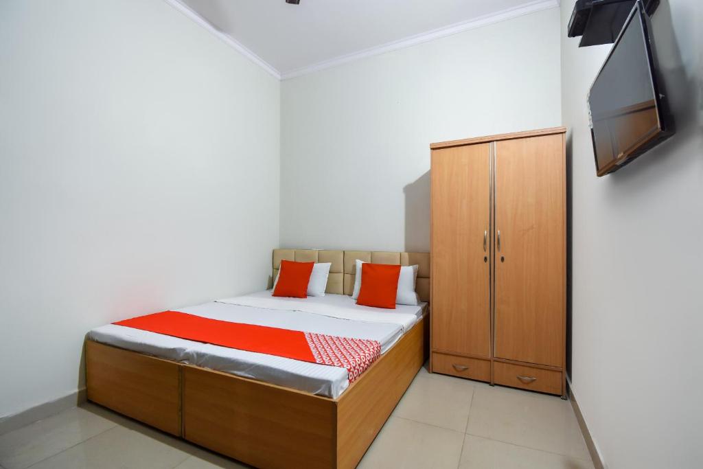 a bedroom with a bed and a cabinet and a tv at Hotel O Sabtera Homes in Kharar