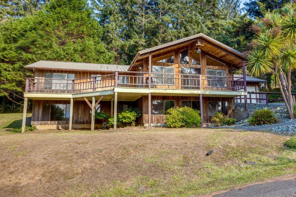 a large wooden house with a large deck at Tree-Lined Gold Beach Retreat w/ Multiple Decks! in Gold Beach