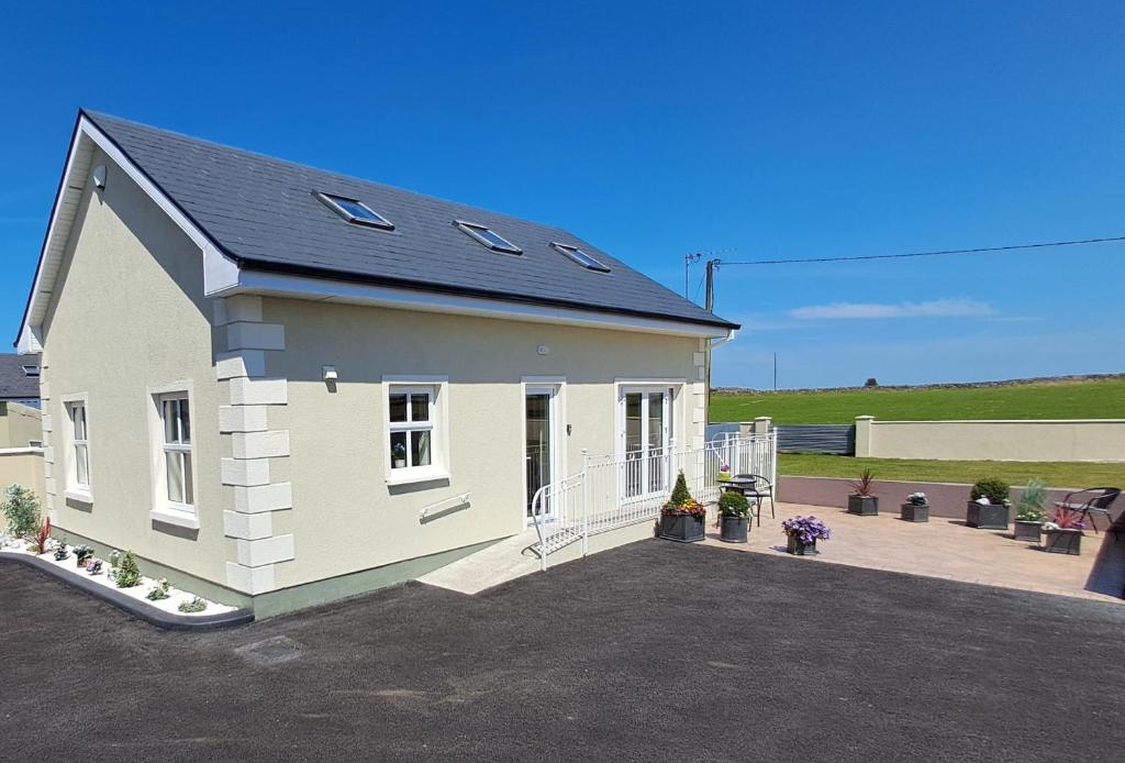 a small white house with a roof at Warm Spacious Three Bed Chalet in Galway