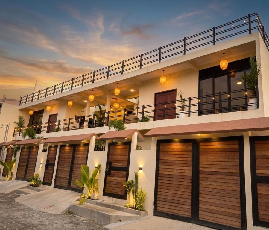 a large white building with wooden garage doors at Itza Living Apartments in Flores