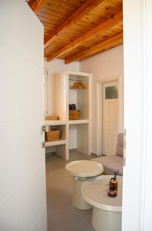 a room with white walls and a wooden ceiling at Omnia Apartments Amorgos No2 in Amorgos