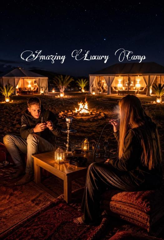 a man and a woman sitting in front of a table at Amazing Luxury Camp in Merzouga