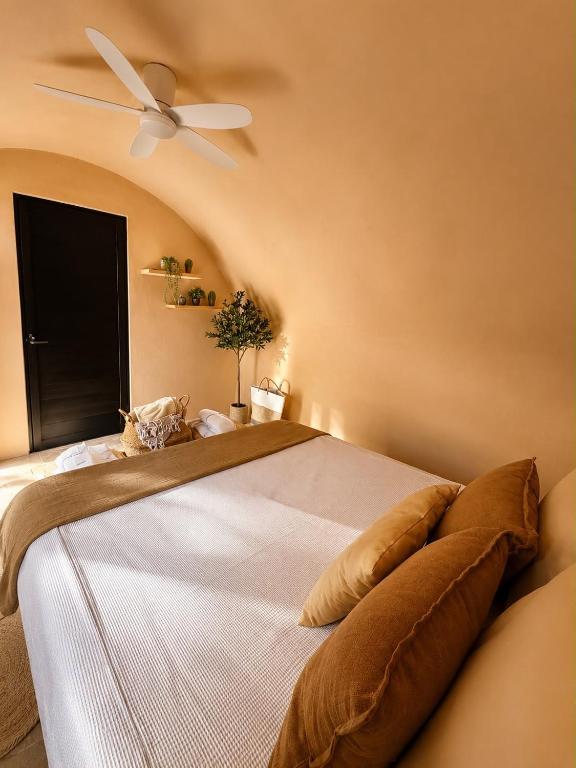 a bedroom with a large bed with a ceiling fan at El campanario Glamping in Jalcomulco