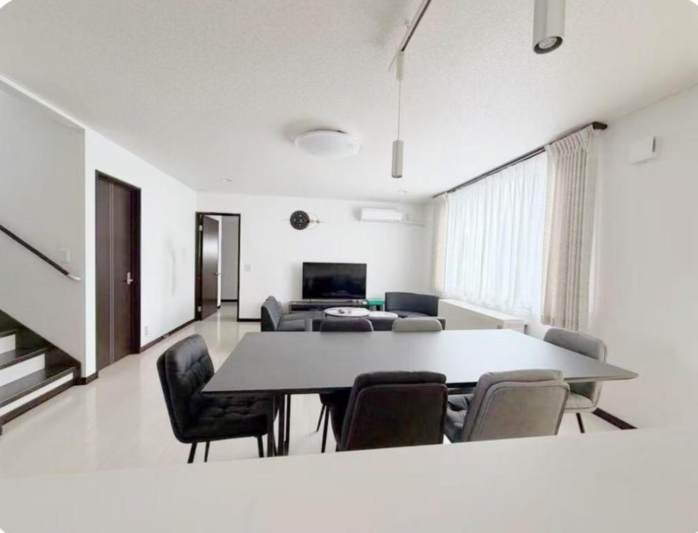 a living room with a table and chairs at ゲストハウス 華園 in Furano