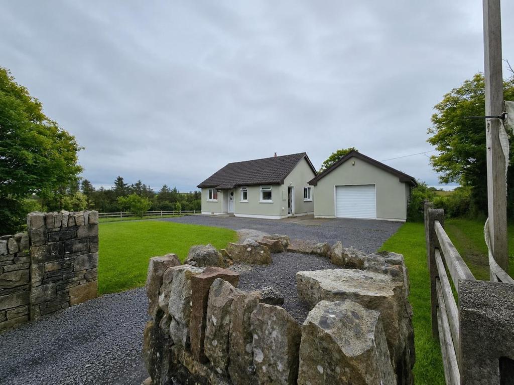 a stone retaining wall in front of a house at Hill House Westport in Mayo