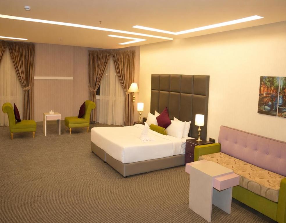 a hotel room with a bed and a couch at فندق نواة العزيزية in Medina