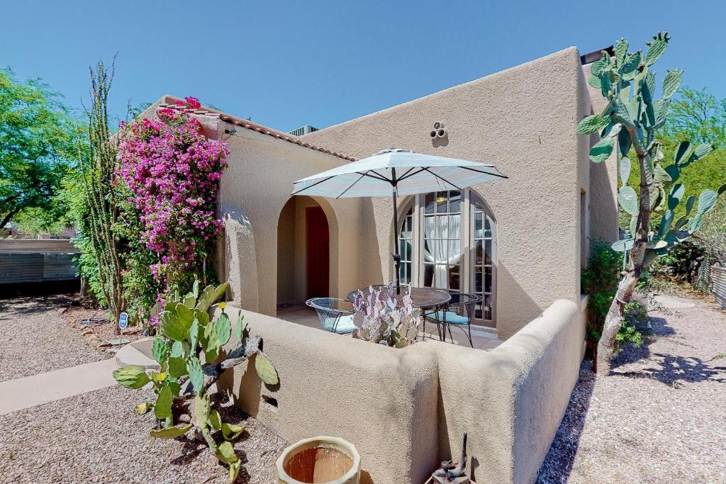 a house with a patio with an umbrella and plants at Historic on 5th in Tucson