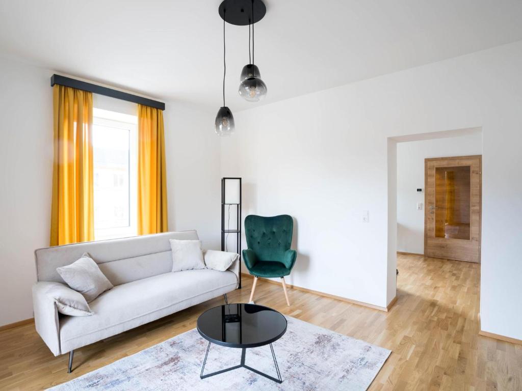 a living room with a white couch and a green chair at Murleben Top 06 in Stadl an der Mur