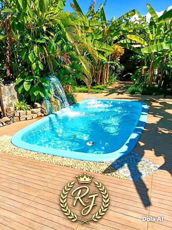 a blue swimming pool on a wooden deck at Pousada Rainha das Águas in Ilhéus