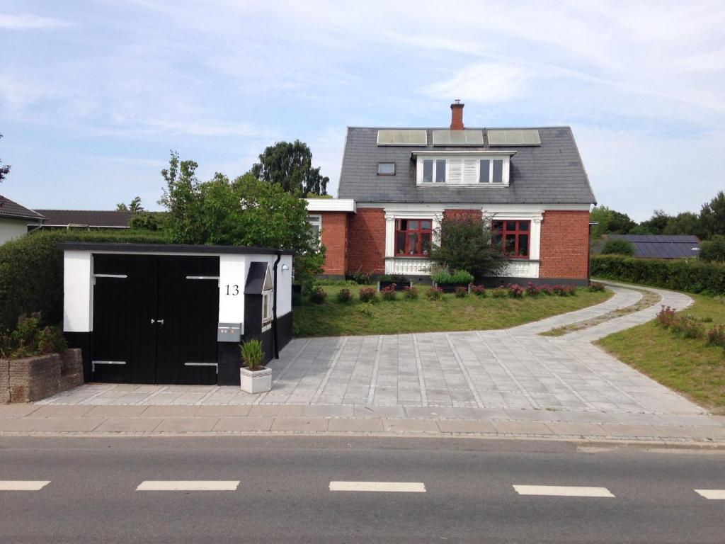 Villa Thurø Homestay في سفينبورغ: منزل بأبواب سوداء وبيضاء وممر