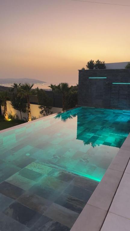 a large swimming pool with blue water at dusk at Villa élite in Tangier