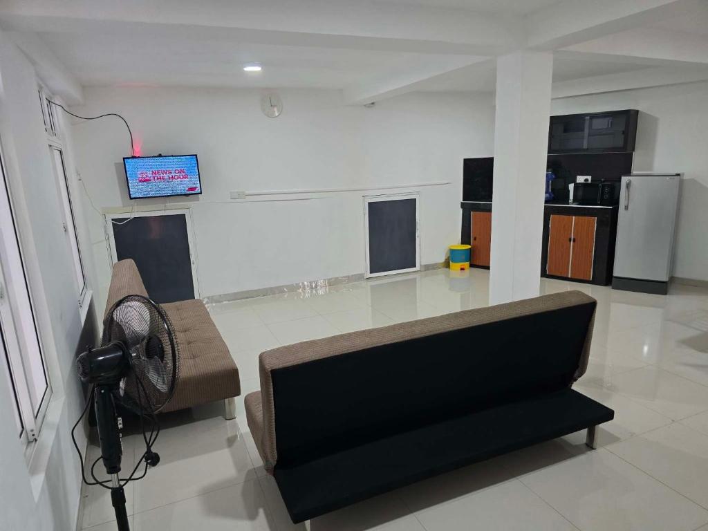 a living room with a couch and a fan at Kandy City View Apartments in Kandy