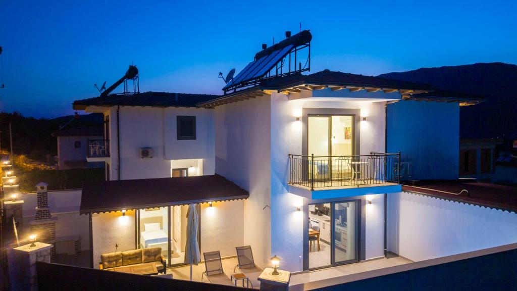 a white house with a swimming pool at night at Villa Kaş B in Kaş