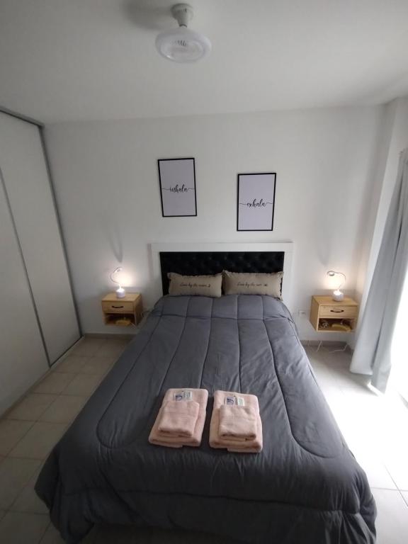 a bedroom with a large bed with two towels on it at WB1c in Puerto Madryn