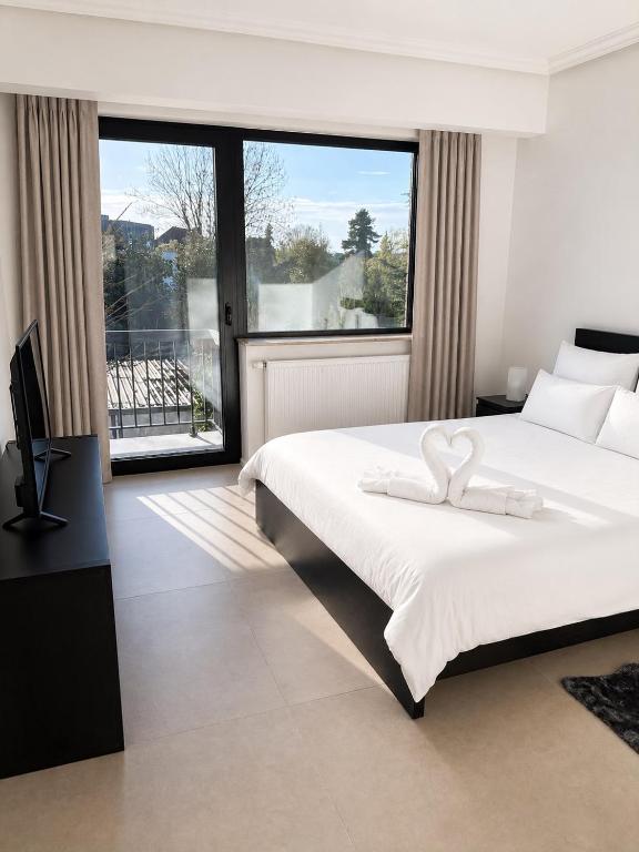 a bedroom with a large bed and a large window at Spacious Apartment 1BR with Sofa bed near Atomium, Expo 12 and ING Arena in Wemmel