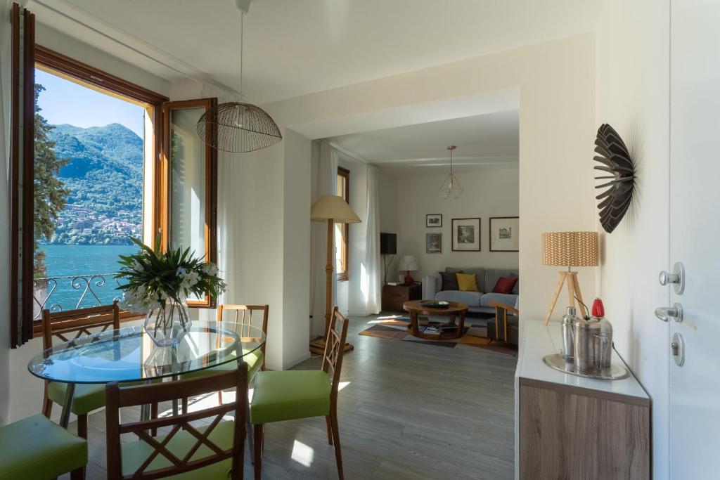 a living room with a table and a view of the ocean at Romantic Pier by Rent All Como in Carate Urio