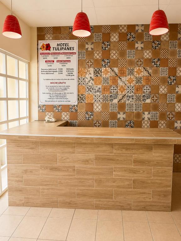 a counter in a restaurant with a tile wall at Hotel Tulipanes in Villahermosa