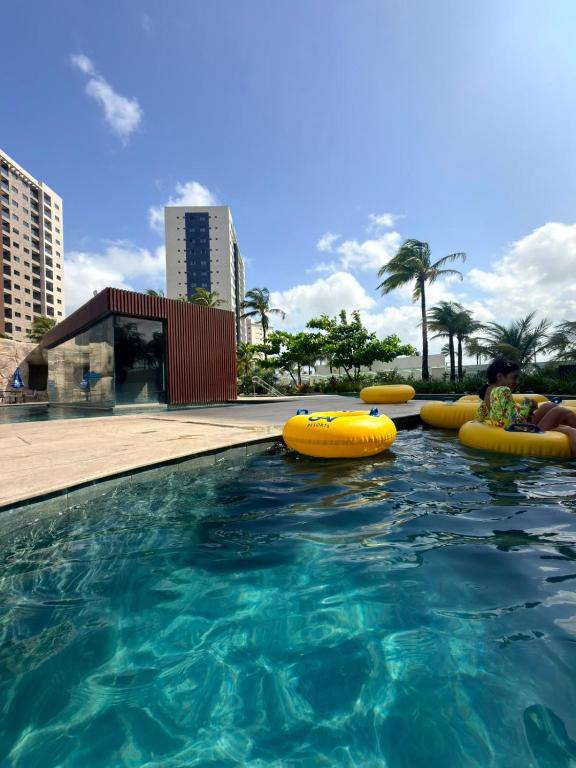 a swimming pool with yellow inflatable tubes in the water at Apartamento em Salinas Premium Resort in Salinópolis