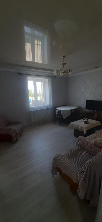 a large room with two beds and two windows at Гостевой дом in Sevan