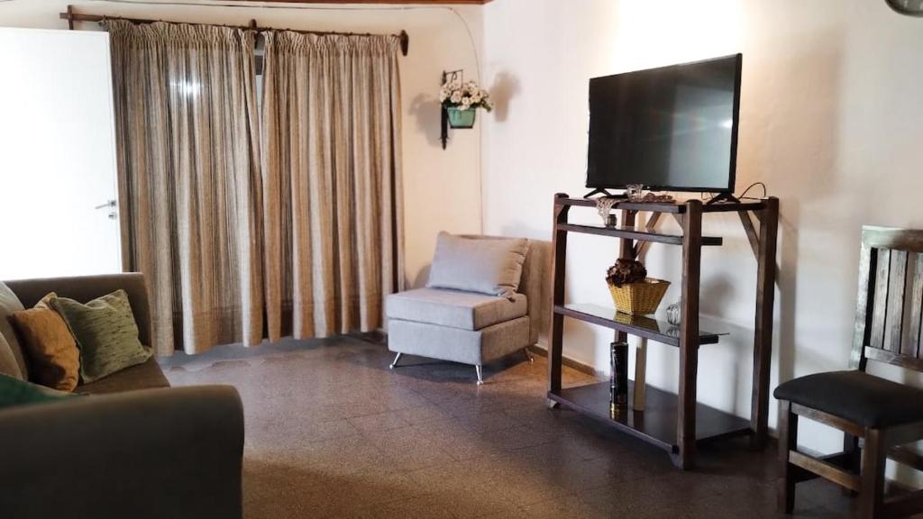 a living room with a flat screen tv and a chair at "Alojamiento en Uspallata" para hasta 6 personas in Uspallata